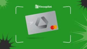 Auf einem grünen Hintergrund ist eine silberne Mastercard-Debitkarte mit einem modernen geometrischen Logo in der Mitte abgebildet, darüber befindet sich das Logo und der Schriftzug „Fincopilot“, während weiße Linien und schwarze Akzente das Design umrahmen.