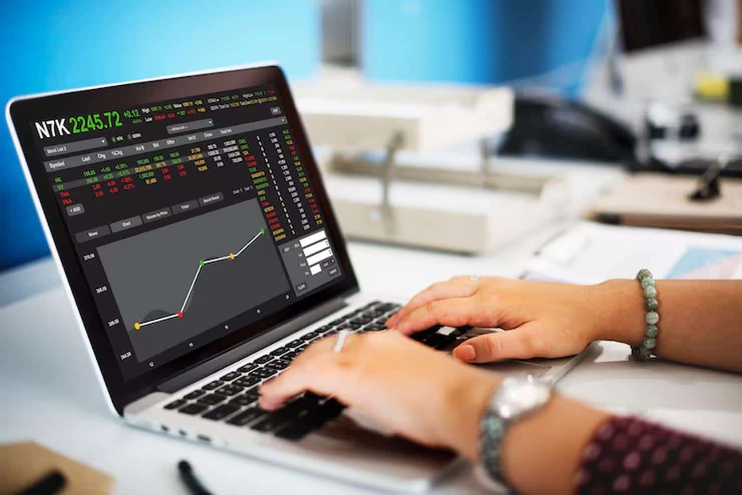 Eine Person analysiert auf einem Laptop ein interaktives Finanzdiagramm mit Kursbewegungen und Marktinformationen – eine typische Szene aus dem digitalen Handel mit ETFs im modernen Anlageumfeld.