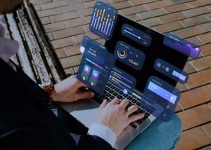 Ein Mann arbeitet an einem Laptop, auf dessen Bildschirm interaktive Diagramme und digitale Finanzdaten projiziert werden – die Szene symbolisiert moderne Anlageplattformen und deren Nutzung durch Technologie für datengetriebenes Investieren.