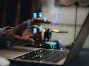 Eine Hand interagiert mit schwebenden digitalen Symbolen und Datenvisualisierungen über einem Laptop – die Darstellung veranschaulicht die technologische Infrastruktur und Analyseprozesse im Kontext der Tokenisierung digitaler Vermögenswerte und Investitionen.