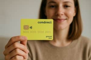 Eine Frau mit braunen Haaren hält eine hellgelbe Comdirect-Girocard in die Kamera und lächelt leicht. Das Bild vermittelt ein Gefühl von Vertrauen und Benutzerfreundlichkeit im digitalen Banking.